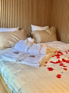 a bed with towels and red flowers on it at Cosy@Beauty in Petit-Rechain