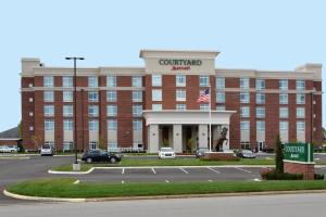 a large red brick building with an american flag at Courtyard by Marriott Youngstown Canfield in Canfield