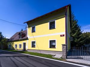 une maison jaune sur le côté d'une route dans l'établissement Žlutý dům - chalupa Krušné hory, à Český Jiřetín