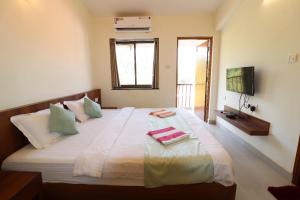 a bedroom with a large bed with two towels on it at Perfect Stay Villa and apartment in Vagator