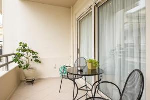 Un balcón con una mesa y sillas y una ventana. en DIEM Studio, en Ioannina