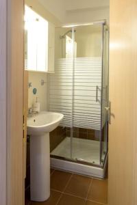 Un baño con ducha de cristal y lavabo. en DIEM Studio, en Ioannina