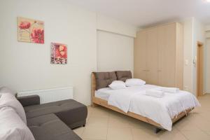 un dormitorio con una cama y un sofá en DIEM Studio, en Ioannina
