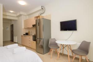 Una cocina con refrigerador y una mesa y sillas. en DIEM Studio, en Ioannina