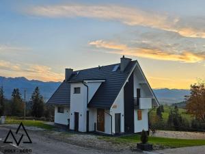 una casa blanca con techo negro en una carretera en HOLY BERG - Dom stworzony z myślą o Tobie - Widok na TATRY - Mountain view en Gliczarów