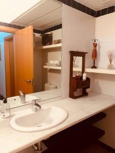 a bathroom with a sink and a mirror at Preciosa Casa de diseño Valle del Este Golf Resort ideal para familias in Vera