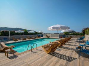 a pool with chairs and umbrellas on a deck at Novotel Nice Centre Vieux Nice in Nice