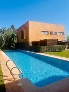 a swimming pool in front of a house at Preciosa Casa de diseño Valle del Este Golf Resort ideal para familias in Vera