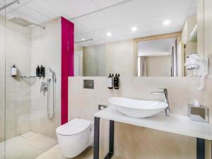 een badkamer met een wastafel, een toilet en een douche bij Mercure Lublin Centrum in Lublin