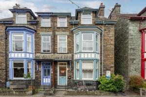 a row of brick houses with blue and white windows at THE AMBLESIDE APARTMENTS - Self catering with private kitchen - Best for Location in Ambleside