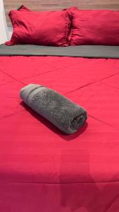 a bed with a gray pillow on a red bed at Klia SomeHouse Homestay in Sepang
