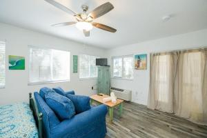 a living room with a blue couch and a ceiling fan at Guld Drive House #54599 Home in Holmes Beach