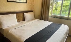 a large bed in a bedroom with a window at FabHotel Prime Golden Feather in Udaipur