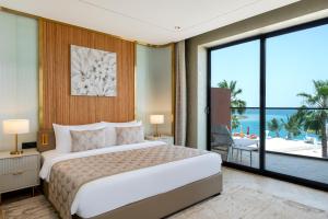 voco Monaco Dubai, an IHG Hotel, Adults Only, World Islands في دبي: غرفة نوم بسرير كبير ومطلة على المحيط
