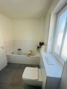 e bagno bianco con servizi igienici e vasca. di Moderne Wohnung in City Nähe a Mörfelden-Walldorf