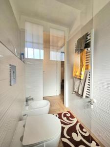 een witte badkamer met een toilet en een wastafel bij Grazioso bilocale ristrutturato vicino alla Stazione/metro in Milaan