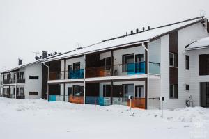 un edificio de apartamentos con nieve delante en Holiday in Lapland - Ylläs Polar Charm B, en Ylläs