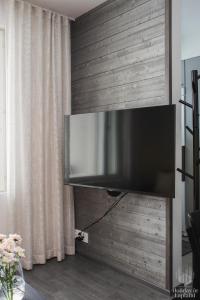 TV de pantalla plana colgada en la pared de la sala de estar. en Holiday in Lapland - Ylläs Polar Charm B, en Ylläs