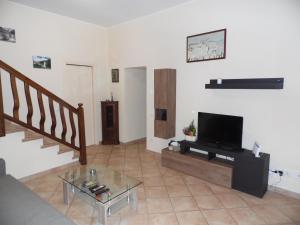 uma sala de estar com um sofá e uma televisão em La vecchia vite casa vacanze em Trevi