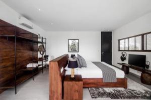 - une chambre avec un grand lit en bois et un bureau dans l'établissement The R Villa Cereme - nature, quite, luxurious, à Tegalalang