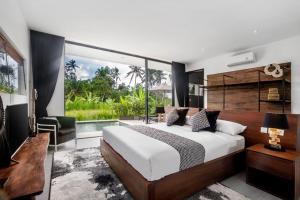 - une chambre avec un grand lit et une grande fenêtre dans l'établissement The R Villa Cereme - nature, quite, luxurious, à Tegalalang
