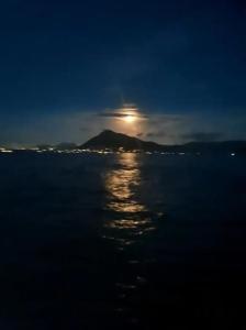 a moonrise over a body of water at night at Cheerful 1 bed vacation home with tours & facilities in La Gaulette