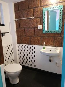 a bathroom with a toilet and a sink and a mirror at Laxmi Happy Home in Querim Goa in Querim