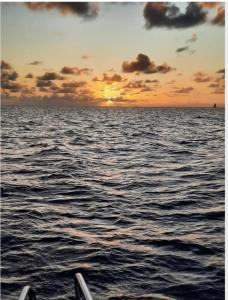 een zonsondergang over de oceaan op een boot bij Cheerful 1 bed vacation home with tours & facilities in La Gaulette