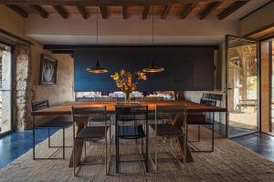 uma sala de jantar com uma grande mesa de madeira e cadeiras em Maison d'architecte - piscine & court de padel privés + vue à 360° 