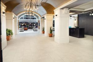 eine leere Lobby mit weißen Säulen und einem Kronleuchter in der Unterkunft Embassy Suites by Hilton Orlando North in Orlando