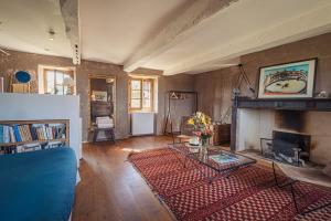 a living room with a blue couch and a fireplace at Maison d'architecte - piscine & court de padel privés + vue à 360° 