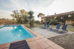 uma piscina com espreguiçadeiras e uma casa em Maison d'architecte - piscine & court de padel privés + vue à 360° 