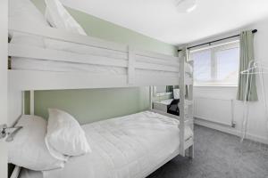 a bedroom with two bunk beds and a window at Comfortable 2 Bedroom Home with Secure Parking in Nottingham