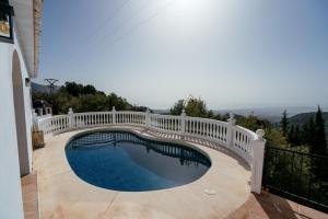 a white fence around a swimming pool with a bridge at Hearts & Home in Mijas