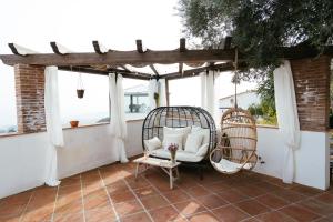 a patio with a chair and two windows at Hearts & Home in Mijas
