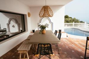 a dining room with a table and chairs and a swimming pool at Hearts & Home in Mijas +68 photos