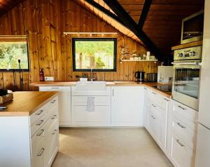 cocina con electrodomésticos blancos y paredes de madera en Chalet - Kleines Paradies -, en Appenzell