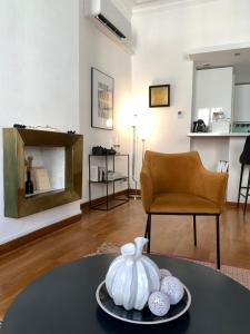 a living room with a table and a chair at Escale citadine au centre d'Avignon, climatisation, appartement de charme, spacieux et lumineux in Avignon