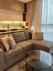 ein Wohnzimmer mit einem Sofa und einem Glastisch in der Unterkunft Dar Alsalam - Premium and Spacious 1BR With Balcony in Noor 2 in Dubai