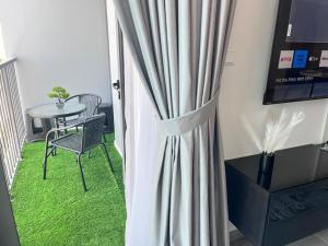 Zimmer mit einem Vorhang, einem Tisch und einem Stuhl in der Unterkunft Dar Alsalam - Premium and Spacious 1BR With Balcony in Noor 2 in Dubai