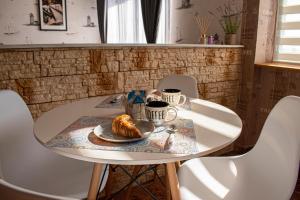 a table with a plate of croissants and cups of coffee at Sunset by Old Town in Constanţa