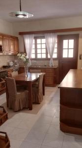 a kitchen with a table with chairs and a tableasteryasteryasteryasteryasteryastery at Spata Efi's House in Spata