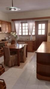 a kitchen with a table with chairs and a tableasteryasteryasteryasteryasteryastery at Spata Efi's House in Spáta