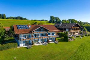 eine Luftansicht eines großen Hauses mit Sonnenkollektoren in der Unterkunft Berg Hotel Weingarten Garni in Rimsting