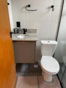 a bathroom with a toilet and a sink at Pousada Portal dos campos in Ponta Grossa