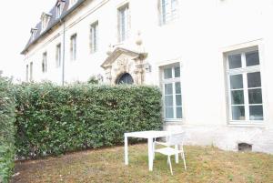 a white table and a chair in front of a building at T2 a Couvent Des Cordeliers in Autun