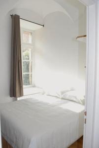 a white bed in a room with a window at T2 a Couvent Des Cordeliers in Autun
