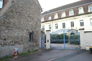 a stone building with a blue gate in front of a building at T2 a Couvent Des Cordeliers in Autun