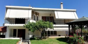 a white house with a balcony and a yard at Spata Efi's House in Spáta
