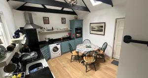 a kitchen with a table and chairs in a room at Newly Renovated stone cottage located 2.5 miles from Killarney Town in Teernaboul